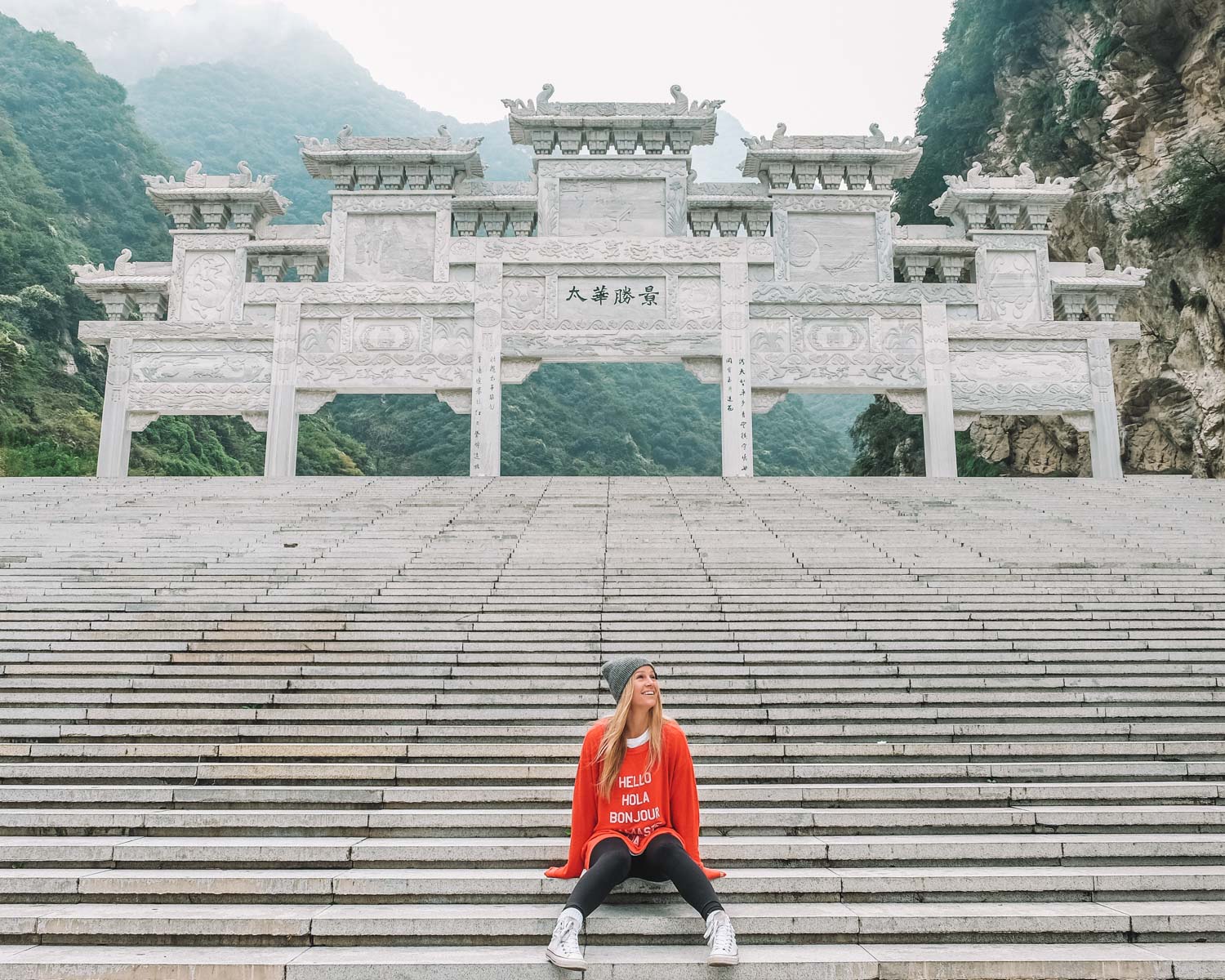 blonde sitting in front of a chinese temple