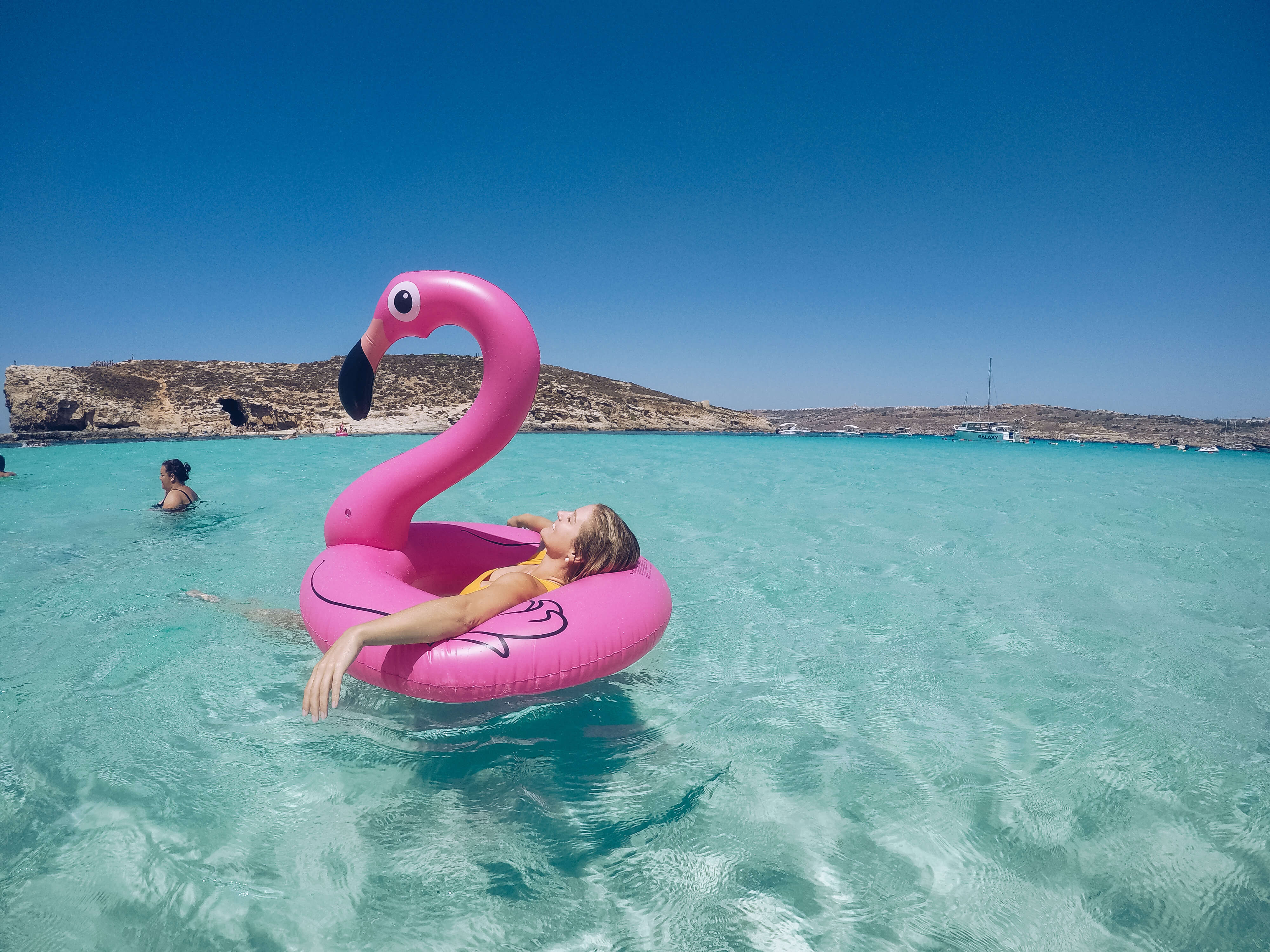 blonde with flamingo in blue lagoon in malta
