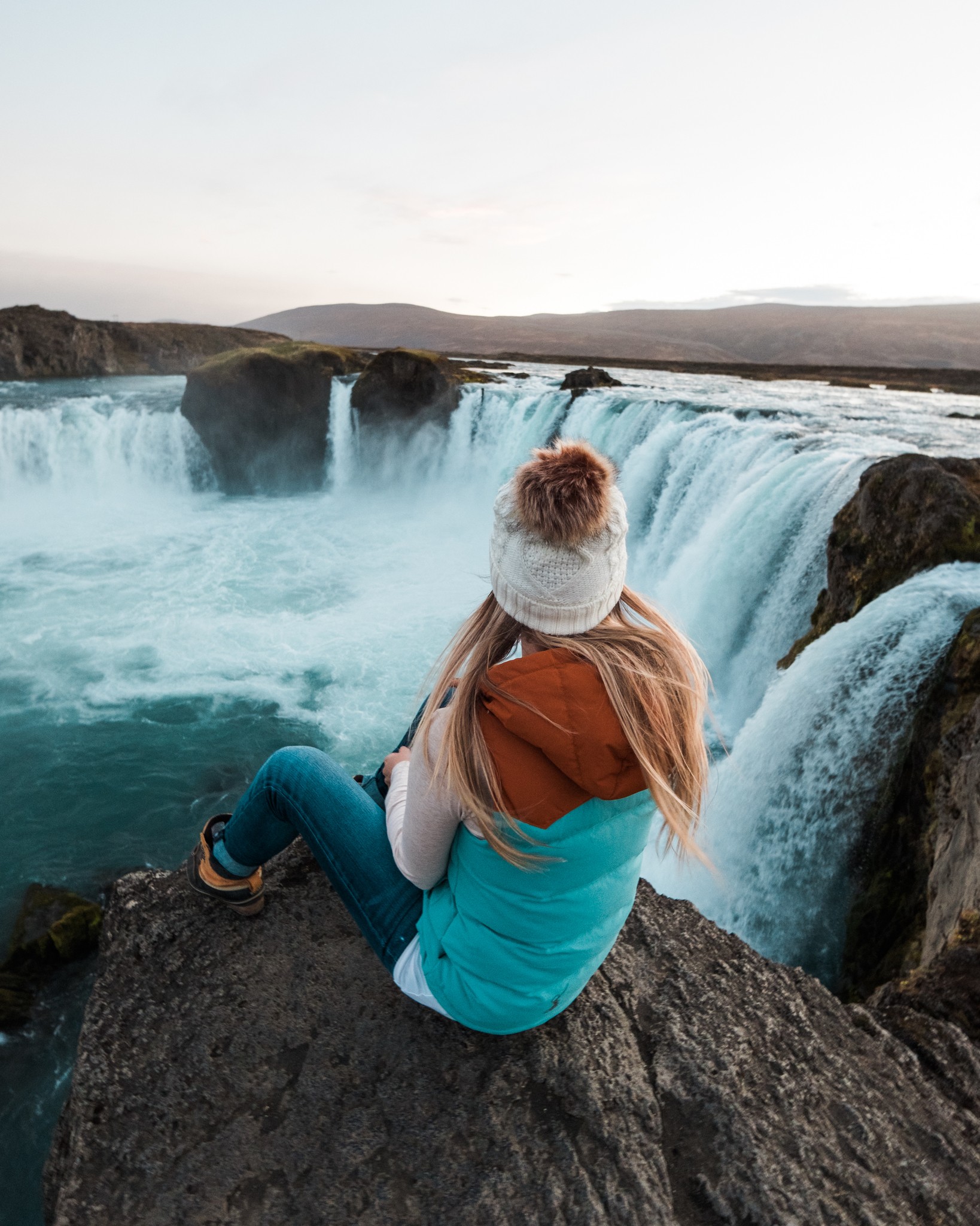 Blonde Sitting at Godafoss Waterfall